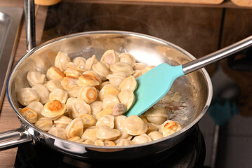 Fried dumplings in a frying pan.