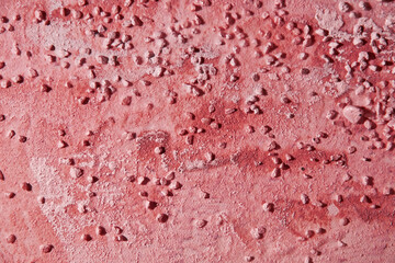 Dark red plaster background wallpaper with a smears and small pebbles. Abstract backgrounds and patterns for interior decor