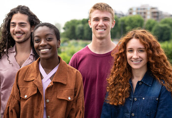 A group of multicultural friends laughing together on a park outdoor.  Friendship, socializing, power of diversity and beauty of friendship concept