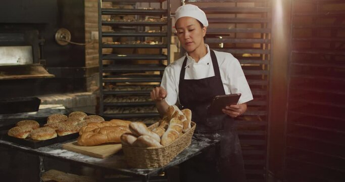 Animation of asina female worker using tablet and counting breads