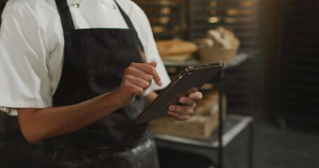 Animation of hands of asian female baker using tablet - Powered by Adobe