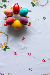 Top view of colored easter eggs on a white tablecloth