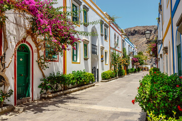 historic center of puerto de mogan with lots of bougainvillea flowers, Canary Island - obrazy, fototapety, plakaty