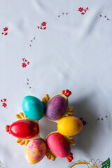 Top view of colored easter eggs on a white tablecloth