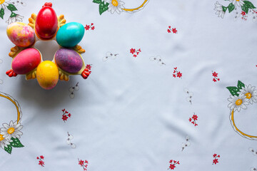 Top view of colored easter eggs on a white tablecloth