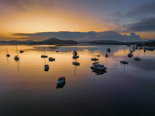 Fototapeta premium Soft and hazy aerial sunrise waterscape with boats