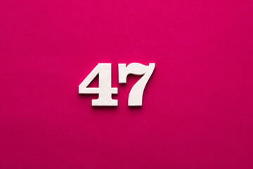 Number 47 - White wooden number on rhodamine red background