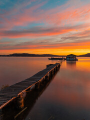 Beautiful sunrise sky over a pier at the lake.