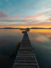 Fototapeta na wymiar Beautiful jetty in the lake with reflection during sunrise.