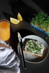 top view a slice of homemade bread with vegan cream cheese and fresh watercress with orange juice 