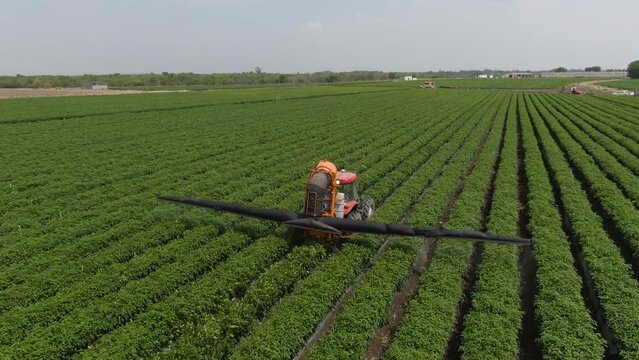 Tractor regando con agua la cosecha