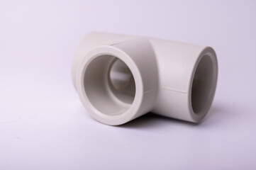 light PVC pipe tee connection for water isolated on light background close up.