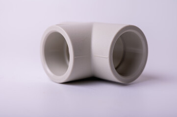 light gray PVC pipe tee connection for water isolated on light background close-up. side view, top view