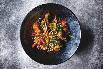 Noodles with seafood and vegetables on a dark background. Asian food