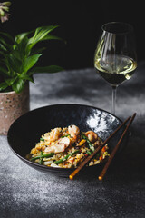 Rice with seafood and vegetables in a beautiful plate on a dark textured background