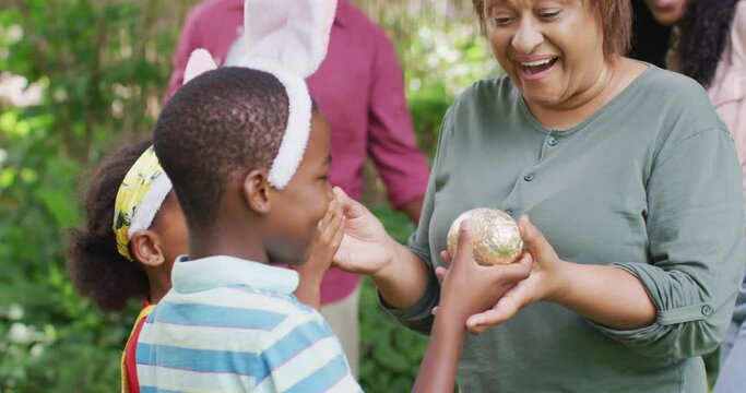 Animation of happy african american family searching for easter eggs in garden
