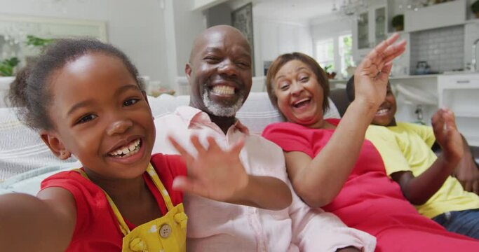 Happy African American Grandparents And Grandchildren Sitting On Sofa, Having Video Call