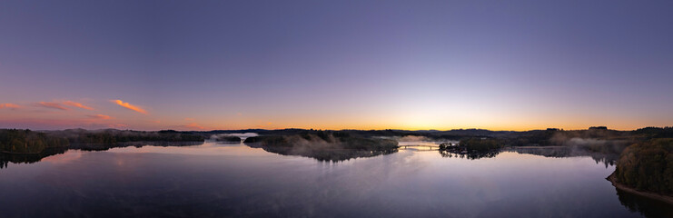 Fototapeta na wymiar Aerial Panoramic of Lac de Saint Pardoux at sunrise with pink and orange colors in autumn