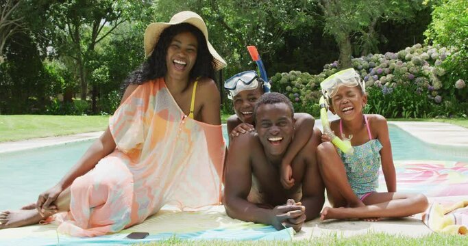 Happy african american family with beach equipment posing to photo at pool
