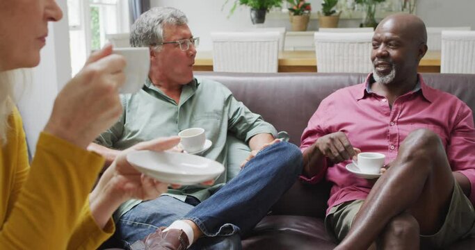 Animation of happy diverse female and male senior friends drinking coffee at home