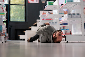 Unconscious person lying on pharmacy floor during epileptic attack, suffering from epilepsy...