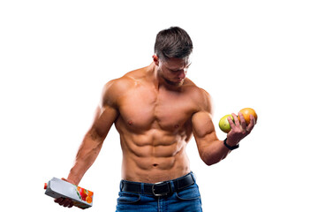 Bodybuilder sportsman holding fruits and juice. Choosing between pure or concentrated drink....