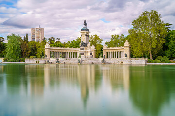 Monument to King Alfonso XII in the pond of the Retiro park in the city of Madrid, during a sunny spring day with blue sky
