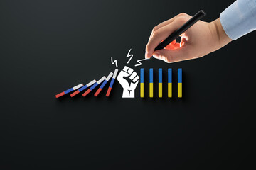 Dominoes with the flag of Russia and the flag of Ukraine, where the fist is stopping Russia. The concept of war caused by Russia, Russia's aggression in Ukraine.