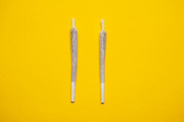 Medical Cannabis Hashish Marijuana rolled Joints isolated on a yellow background. Cool flat lay,...