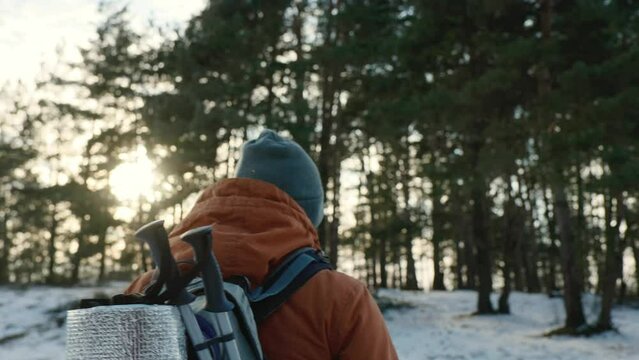 Traveler Man with backpack hiking in winter snowy forest landscape Travel Lifestyle concept adventure active vacations outdoor cold weather into the wild