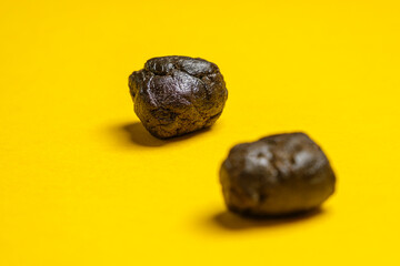 Pieces of high quality Pakistani hashish isolated on a yellow background. Medical marijuana extraction hash cannabis pollen hashish