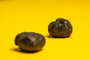 Pieces of high quality Pakistani hashish isolated on a yellow background. Medical marijuana extraction hash cannabis pollen hashish