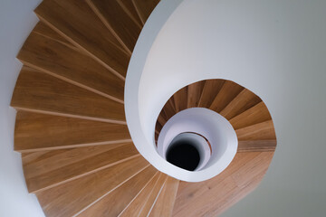 top view of wooden and white stone spiral staircase in the modern building design, indoors...