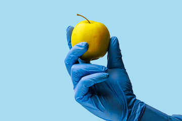 An apple in the doctor's hand. Background, selective focus. Isolated blue medical backdrop
