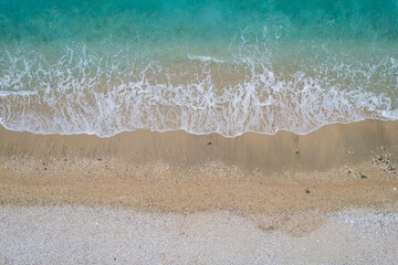 Straight down view on waves and shore of small stones by Bunec Beach area in Summer 2022, Albania
