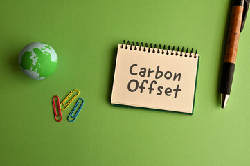 There is a notebook with the word Carbon Offset. It is eye-catching image.