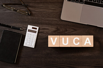 There is wood cube with the word VUCA. It is eye-catching image.