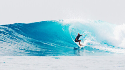 Surfer rides the wave during day