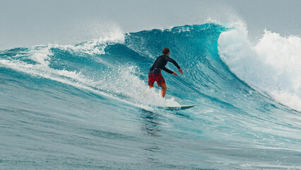 Surfer rides the wave during day