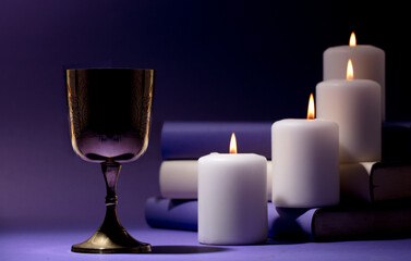 golden christian chalice with candles and purple background