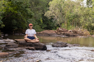 Mujer joven al aire libre realizando yoga y meditación.