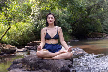 Mujer joven al aire libre realizando yoga y meditación.