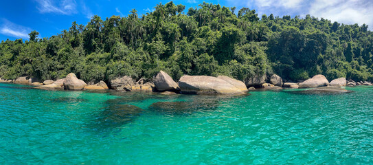 Paraty, Brazil. Blue Lagoon. Sea with clear turquoise water, rocks and diving spots. Tropical forest and blue sky.