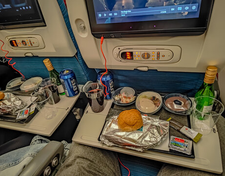 07 05 2022 - Bangkok, Thailand. Front view photo of food and drinks in a plane during a flight. Eating and watching film
