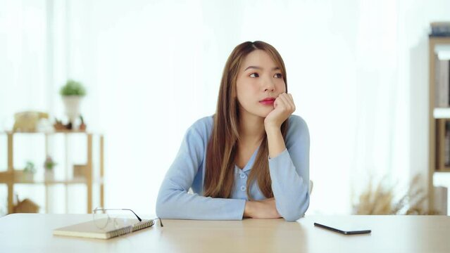 Distracted from work worried young asian woman thinking of problems. Pensive unmotivated lady looking at window, feeling lack of energy
