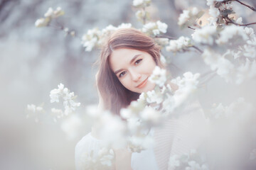 springtime fashion portrait of a young girl in a blooming cherry garden, tenderness of the morning