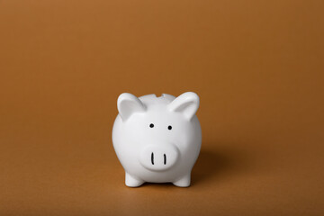 Ceramic piggy bank on brown background. Financial savings