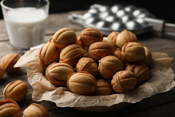 Bowl of delicious nut shaped cookies on wooden table, closeup