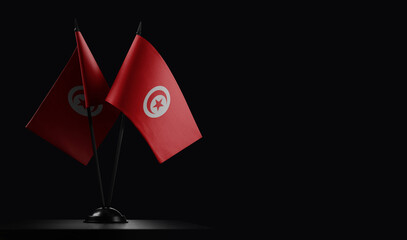 Small national flags of the Tunisia on a black background