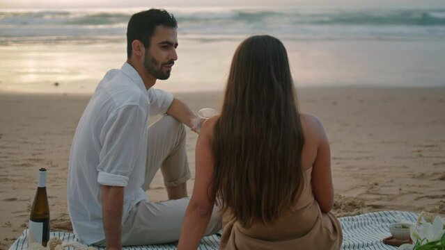 Romantic lovers relaxing ocean beach back view. Latin man speaking unknown woman